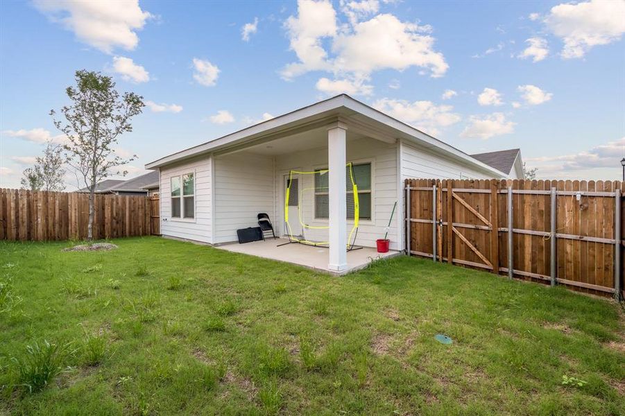 Rear view of house with a yard and a patio