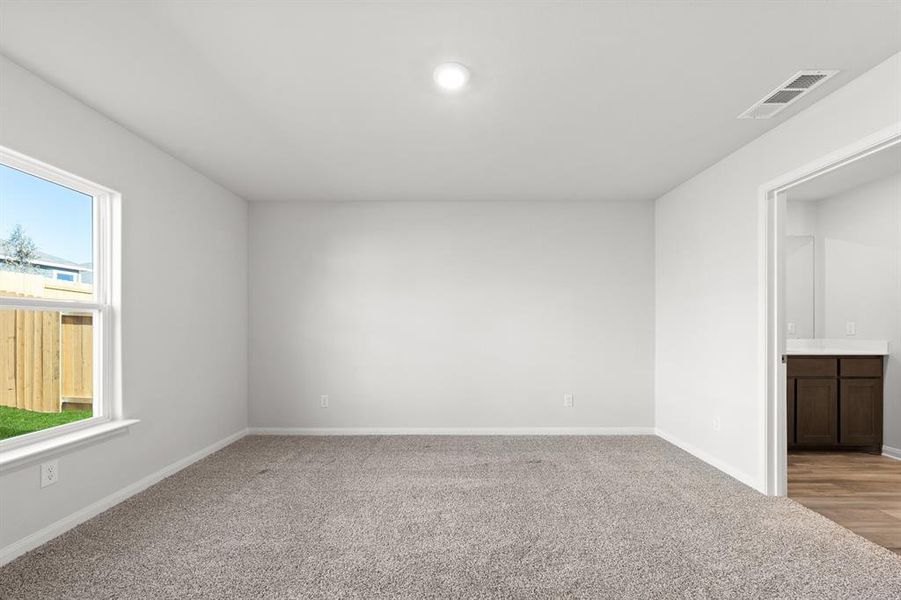 Empty room with light colored carpet and plenty of natural light