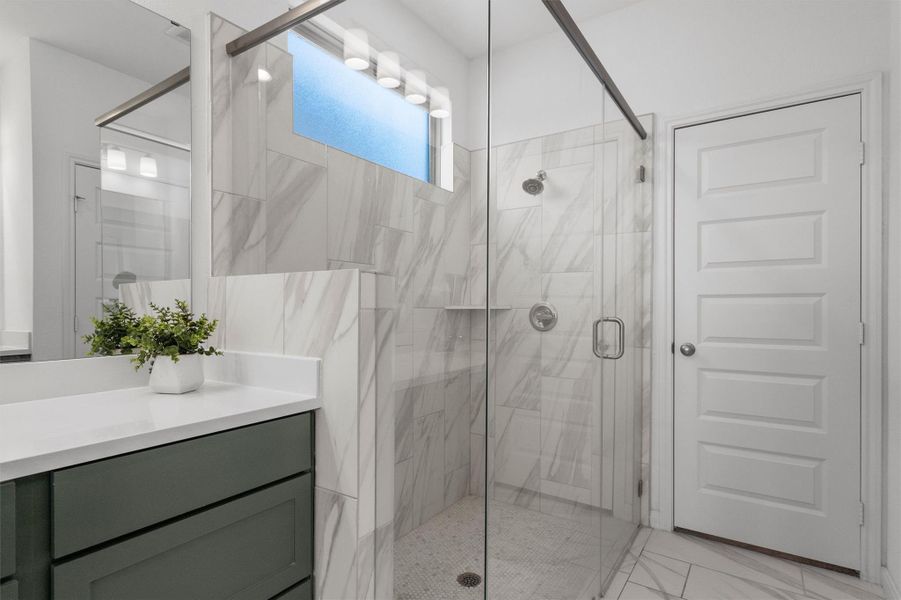 Bathroom with a marble finish shower and vanity