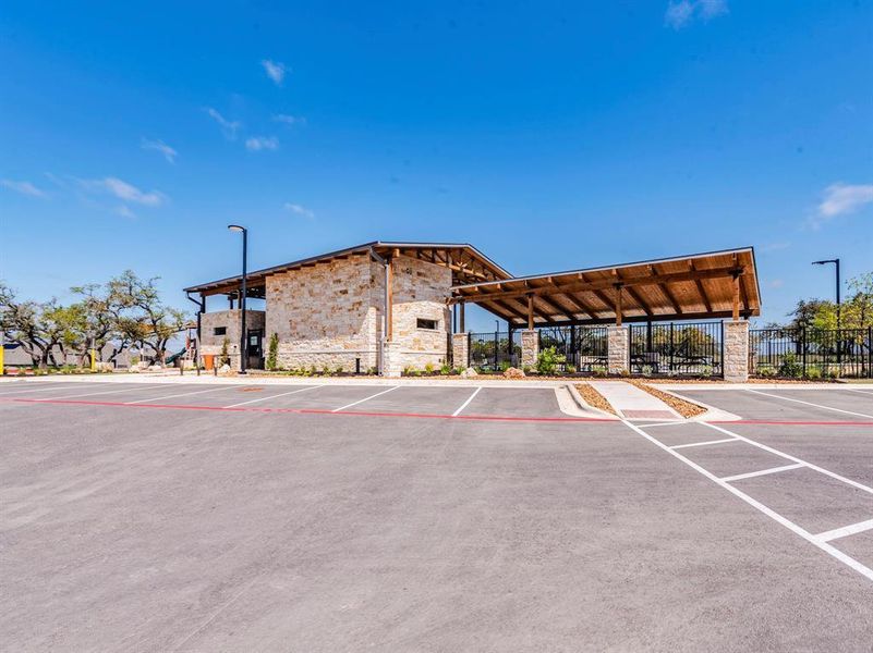 A community gathering space features a stone and wood structure with a large covered patio, ideal for outdoor events.