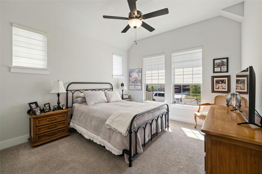 Bedroom featuring vaulted ceiling, carpet, and ceiling fan Bedroom featuring vaulted ceiling, carpet, and ceiling fan