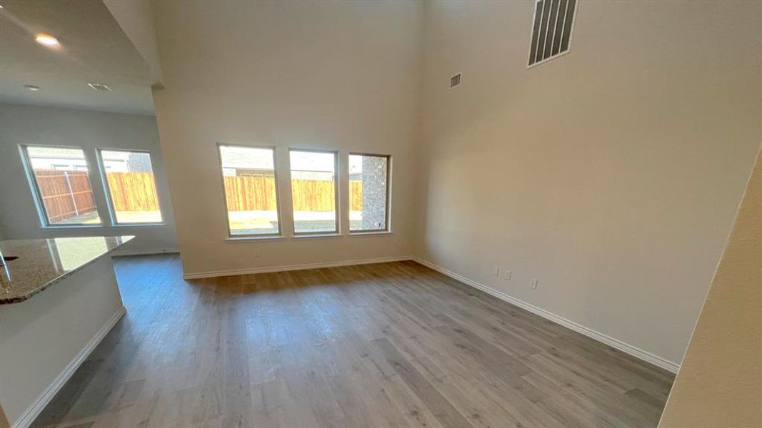 Empty room with light wood-style floors and a high ceiling