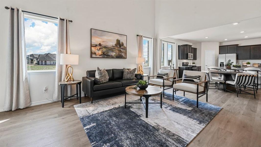 Living room with recessed lighting, light wood finished floors, and a towering ceiling Living room with recessed lighting, light wood finished floors, and a towering ceiling