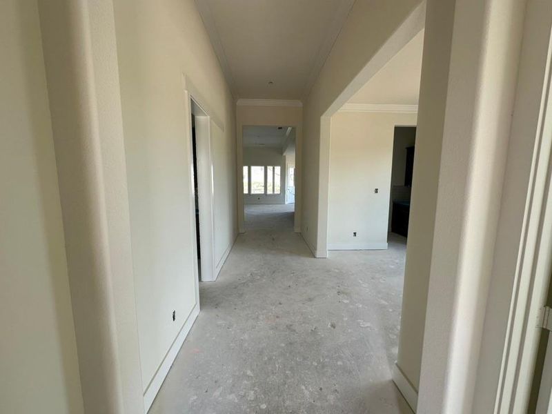 Hallway with crown molding and baseboards