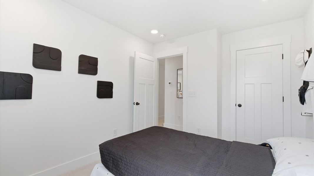 Superior comfort in a secondary bedroom with plush carpet and an oversized walk-in closet at the Churchill Design Superior comfort in a secondary bedroom with plush carpet and an oversized walk-in closet at the Churchill Design