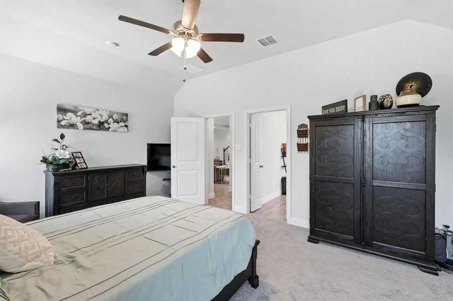 Carpeted bedroom with lofted ceiling and a ceiling fan