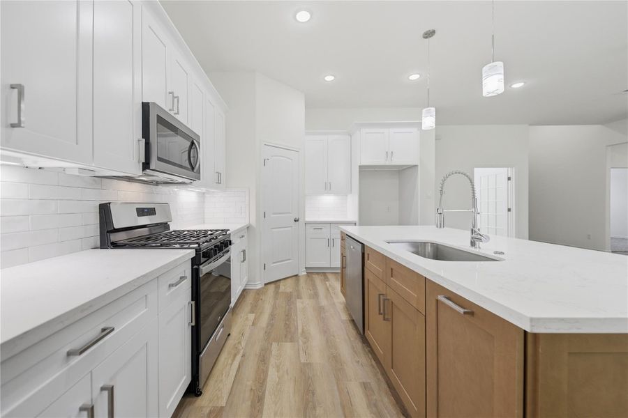 Fresh, Clean, NEW Kitchen with island and gas range, dishwasher, and microwave.