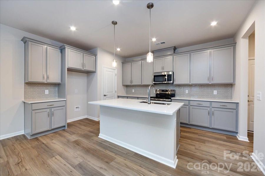 Chef Inspired Kitchen with Steel Grey Cabinets and White Quartz Countertops