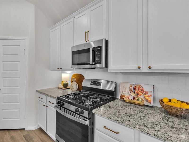 Designed backsplash and modern hardware make this kitchen a showstopper!