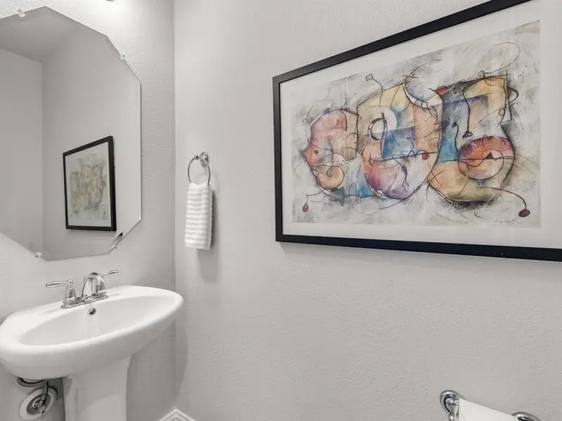 Convenient second-floor powder bath for guests features a classic, space-saving porcelain pedestal sink.