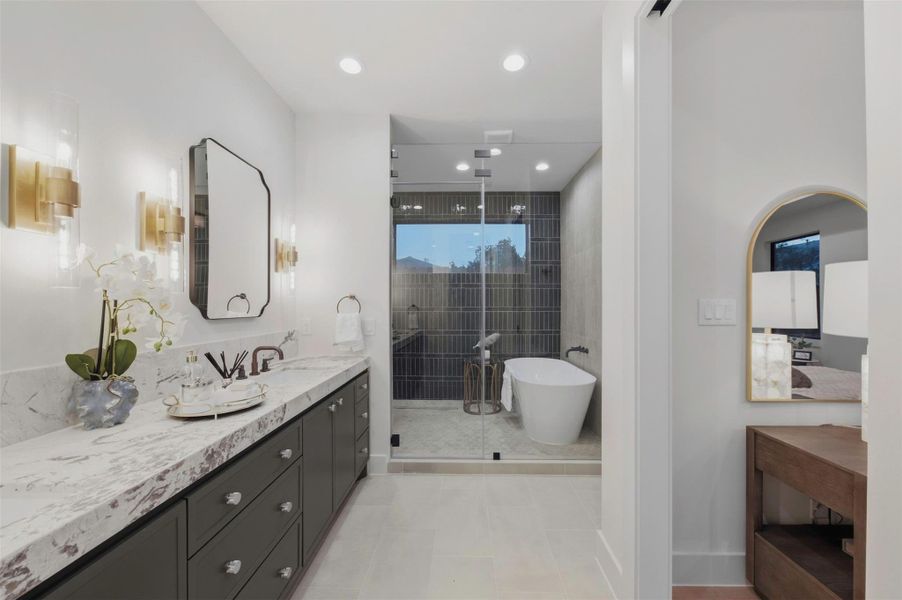 Dual custom vanities in the primary bath offer exceptional storage while continuing the home’s signature white oak design.