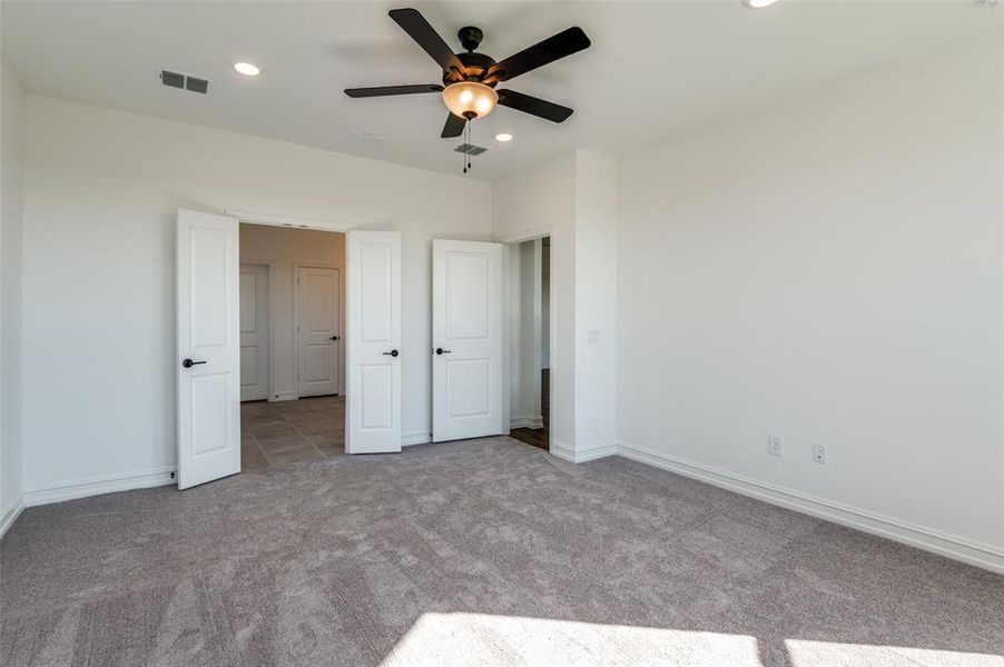 Unfurnished bedroom featuring light carpet and ceiling fan