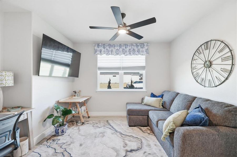 Living room featuring baseboards and ceiling fan
