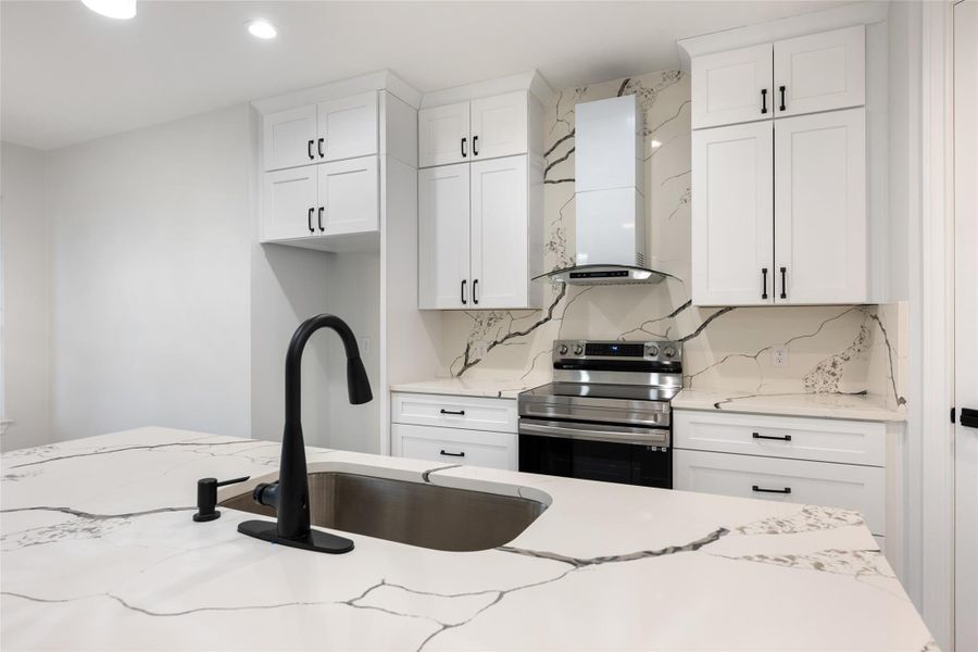 Kitchen with stainless steel range with electric cooktop, tasteful backsplash, white cabinetry, and recessed lighting