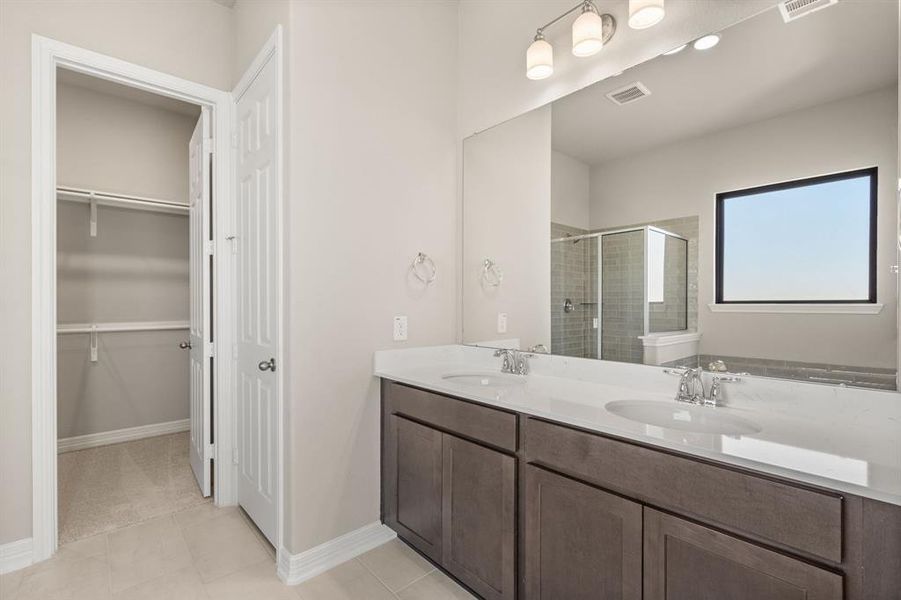 The en-suite bathroom offers a spa-like atmosphere with its elegant design, high end finishes, and tasteful lighting, creating a retreat within your own home.