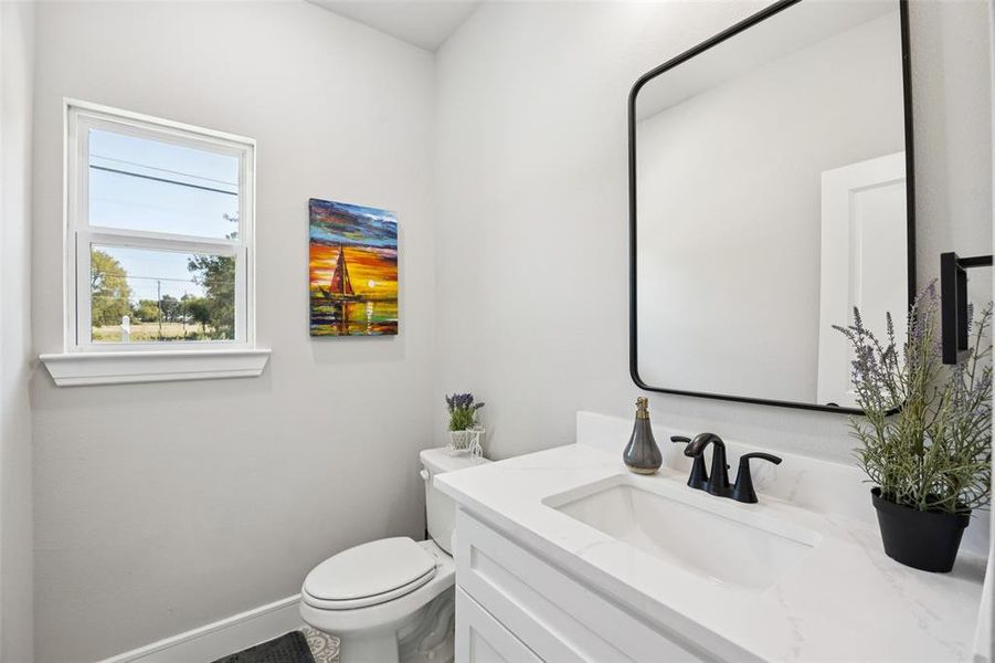 Half bathroom featuring vanity and toilet