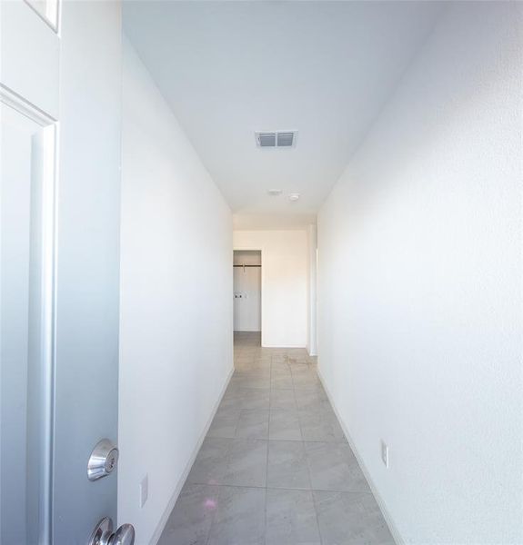 Hallway featuring light tile patterned floors