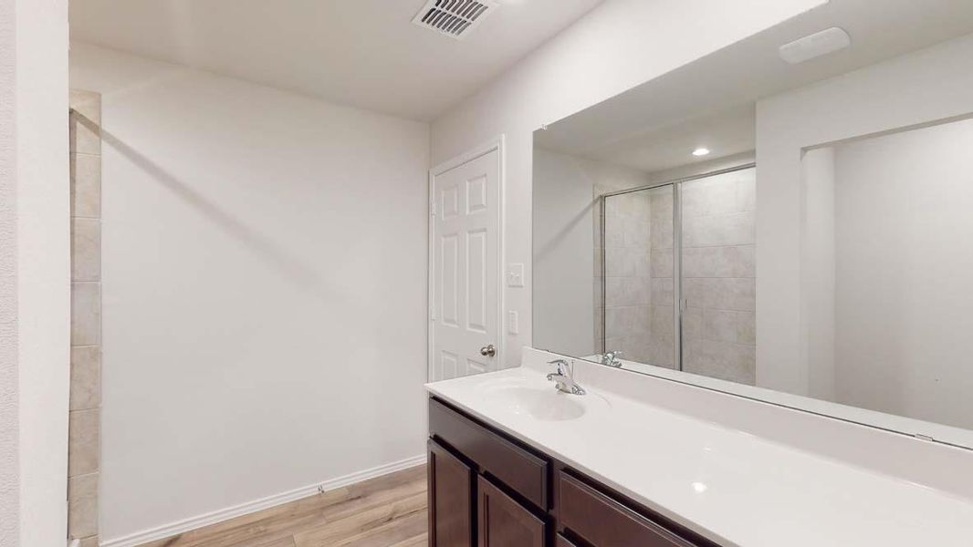 White vanity with integrated sink, chrome faucet, and quartz countertop