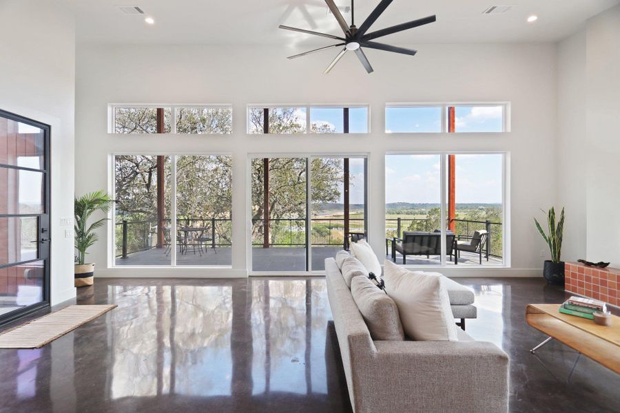 Living area with a ceiling fan, plenty of natural light, a towering ceiling, recessed lighting, and baseboards Living area with a ceiling fan, plenty of natural light, a towering ceiling, recessed lighting, and baseboards