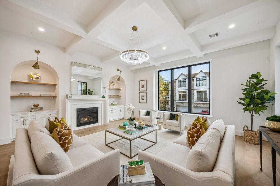 A refined yet welcoming living room that blends classic architectural details with modern comfort. Painted Boxed Beamed ceiling, Arched builtins and a centered cast stone fireplace provide timeless structure, while soft lighting add warmth and sofistication. Large windows flood the space with natural light, making it ideal for both relaxing and entertaining.