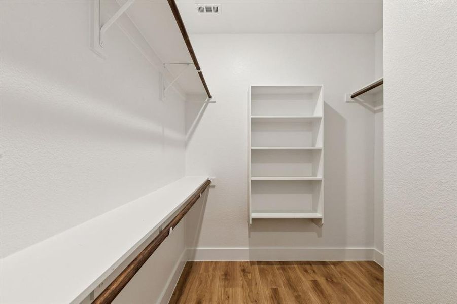 Walk in closet with light wood-style floors