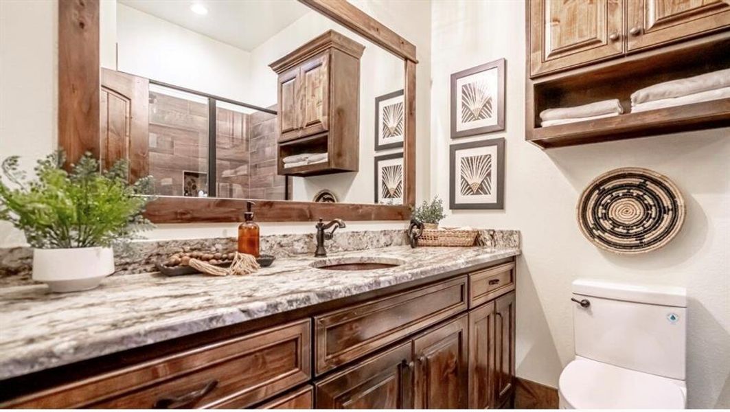 Full bathroom with toilet, vanity, and tiled shower Full bathroom with toilet, vanity, and tiled shower