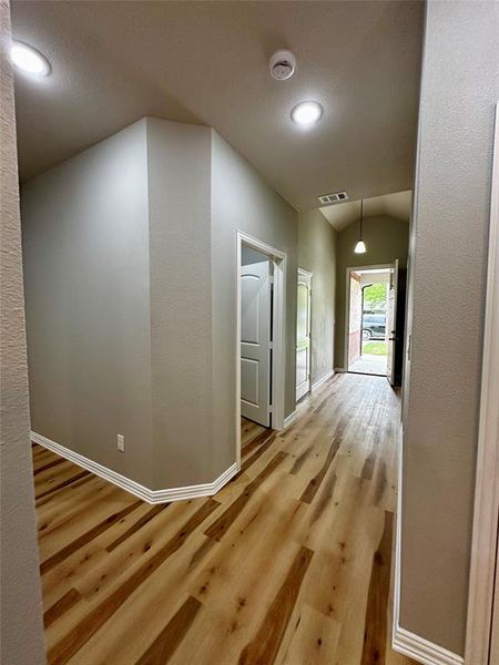 Hall featuring lofted ceiling and wood-type flooring