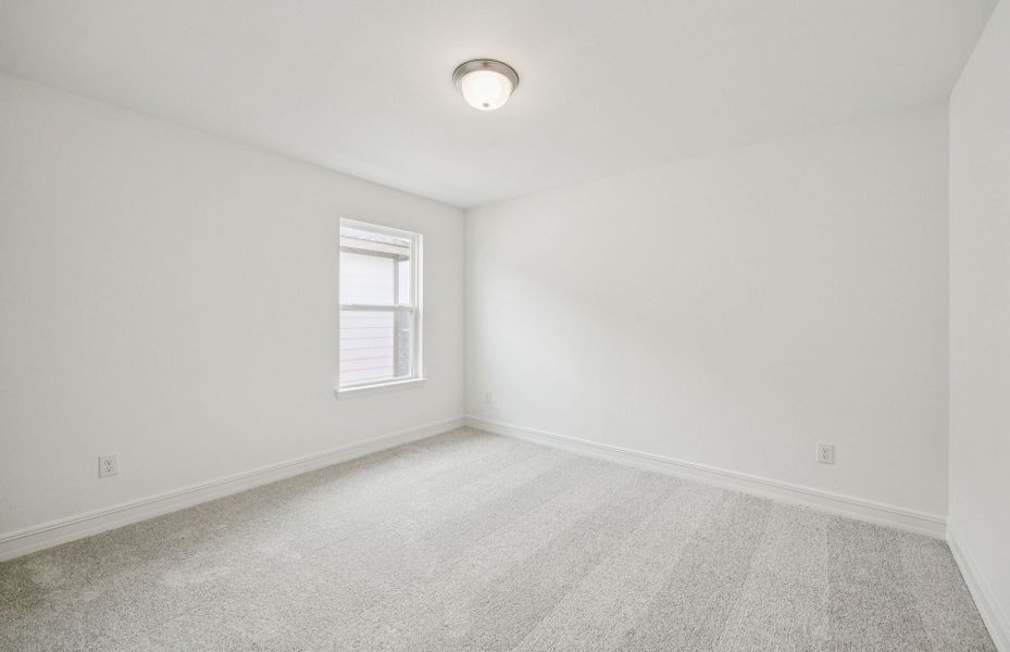 Roomy secondary bedroom with extensive closet storage  *Real home pictured