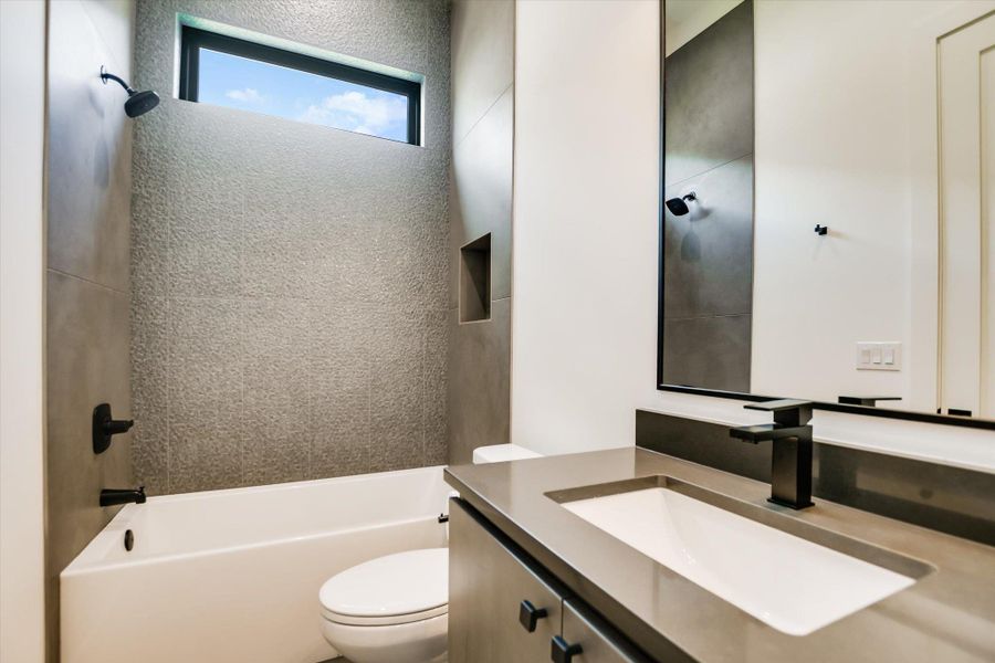 A well-appointed bath features modern fixtures and a window for natural illumination.
