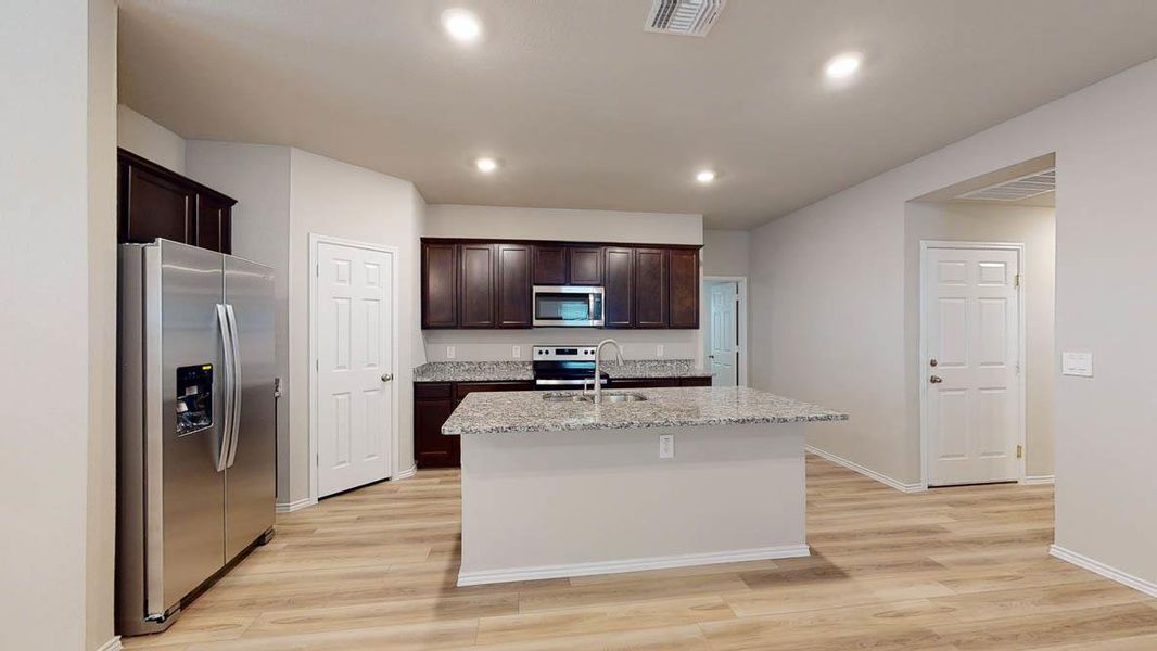 A well-appointed kitchen features rich cabinetry, generous counter space, and a functional island with a sink. A well-appointed kitchen features rich cabinetry, generous counter space, and a functional island with a sink.