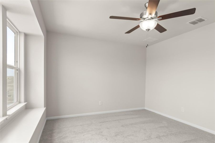 Carpeted spare room with a ceiling fan and baseboards Carpeted spare room with a ceiling fan and baseboards