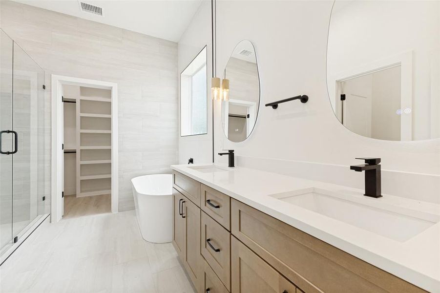 Double vanity with under-mount sinks, light wood-finish cabinetry, and matte black fixtures Double vanity with under-mount sinks, light wood-finish cabinetry, and matte black fixtures