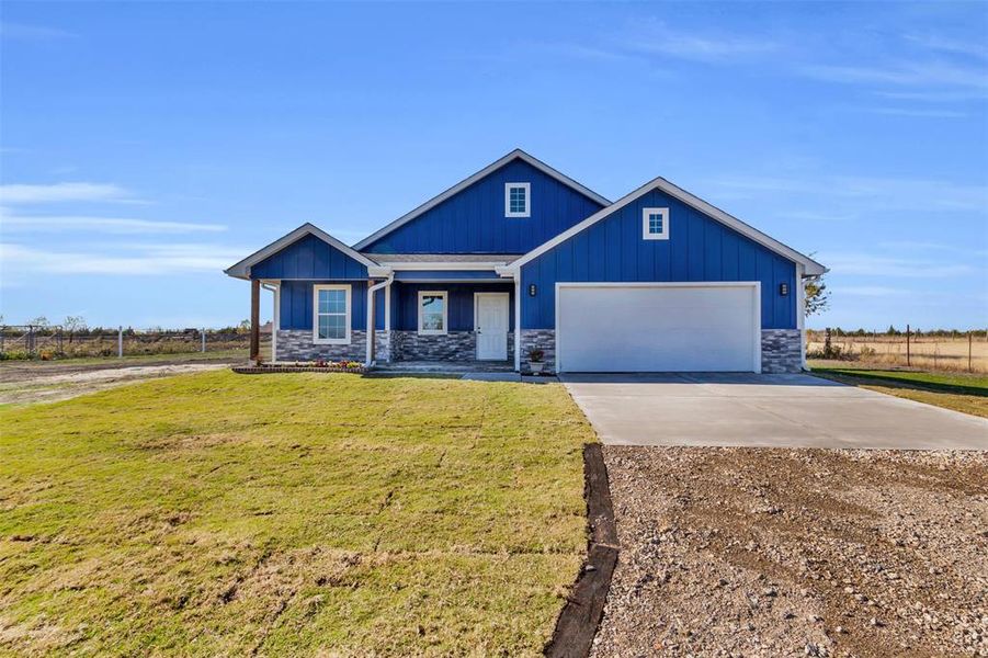 Craftsman house with a garage and a front lawn