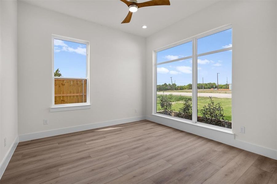 This room features light-toned flooring, white walls, and a contemporary ceiling fan This room features light-toned flooring, white walls, and a contemporary ceiling fan