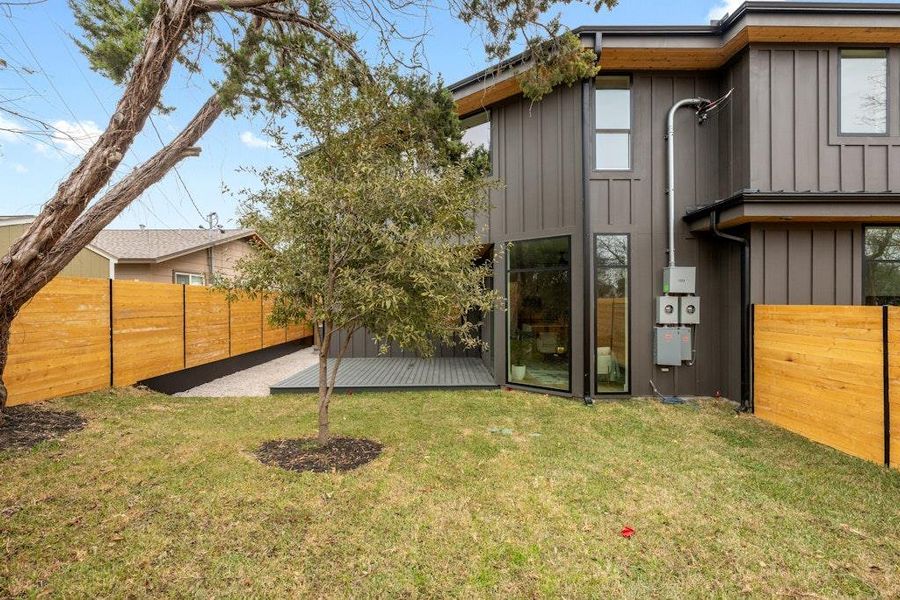 Rear view of house with board and batten siding and a deck