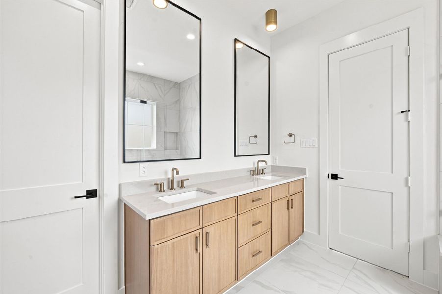 Dual sinks, beautiful cabinetry and quartz countertops enhance the primary bathroom. Dual sinks, beautiful cabinetry and quartz countertops enhance the primary bathroom.
