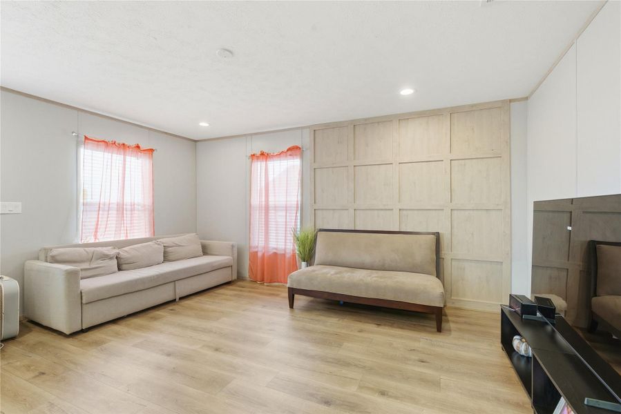 Recessed lighting and a decorative accent wall complement this airy living area.