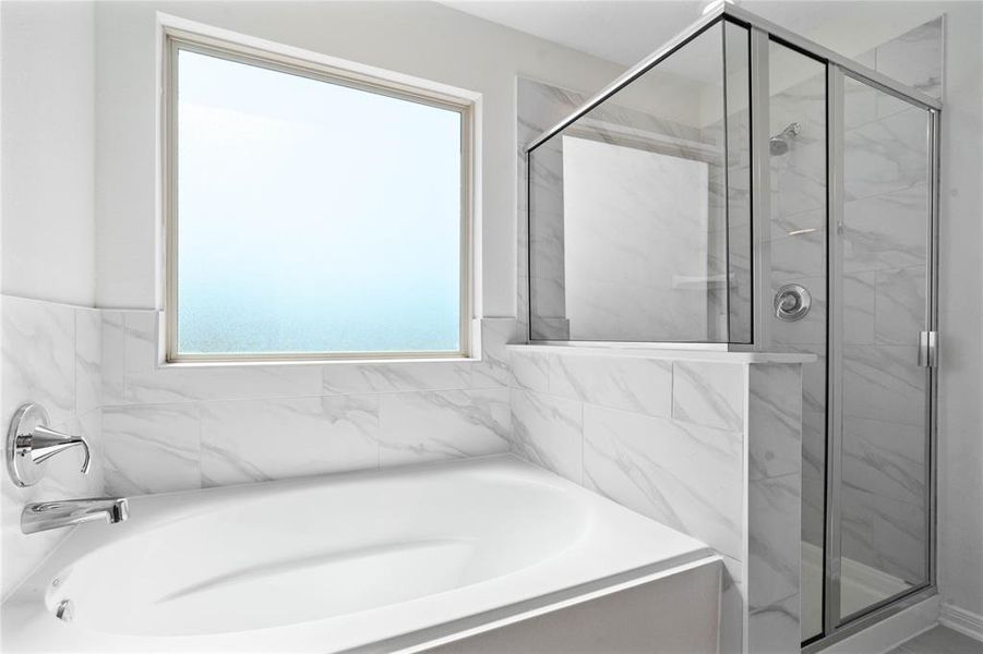 This primary bathroom is definitely move-in ready! Featuring a walk-in shower with tile surround, separate garden tub for soaking after a long day with custom tile detailing, custom paint, sleek and large windows to bring in the natural light.