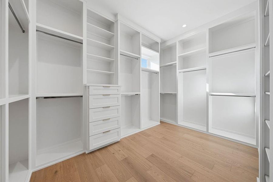 The primary suite is completed by a massive, custom-designed walk-in closet that combines high-capacity storage with the clean, sophisticated aesthetic found throughout the home. Designed for maximum organization, this window-lit space offers a curated environment for even the most extensive wardrobes.