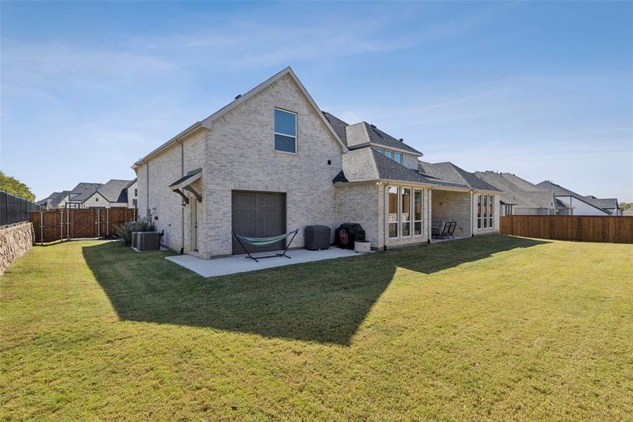 Rear view of house with a patio area, a yard, and cooling unit