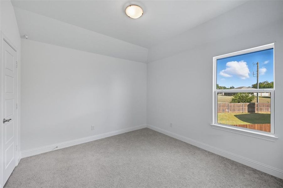 Spare room featuring light colored carpet and baseboards