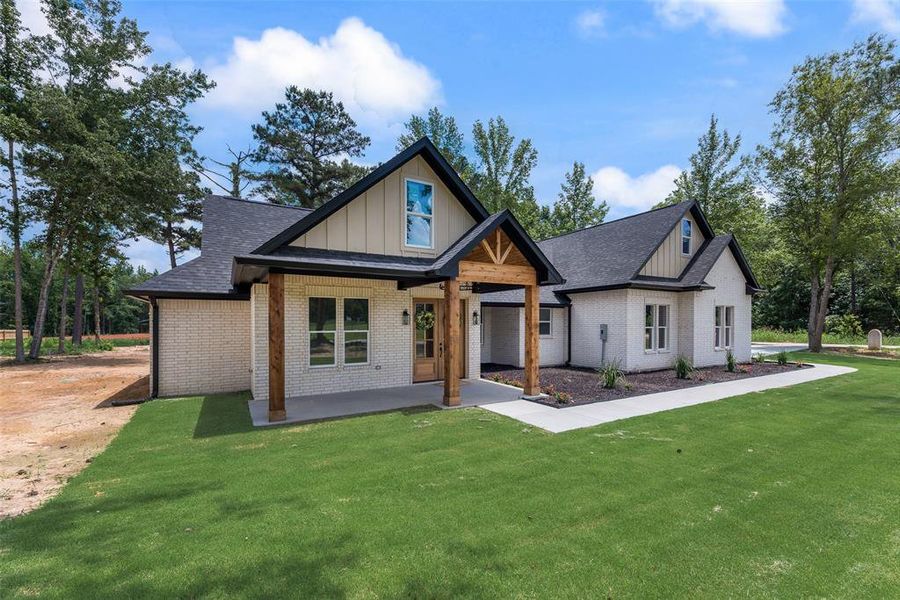 New construction residence featuring a light brick exterior and dark shingle roofing