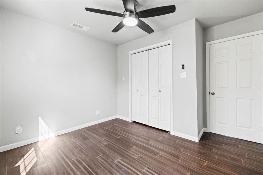 bedroom with dark wood finished floors, a ceiling fan, and a closet