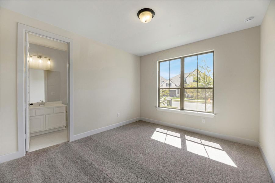 Unfurnished bedroom featuring light carpet and ensuite bath
