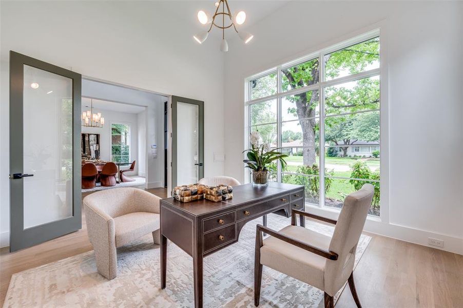 Office area with light hardwood / wood-style floors and a notable chandelier