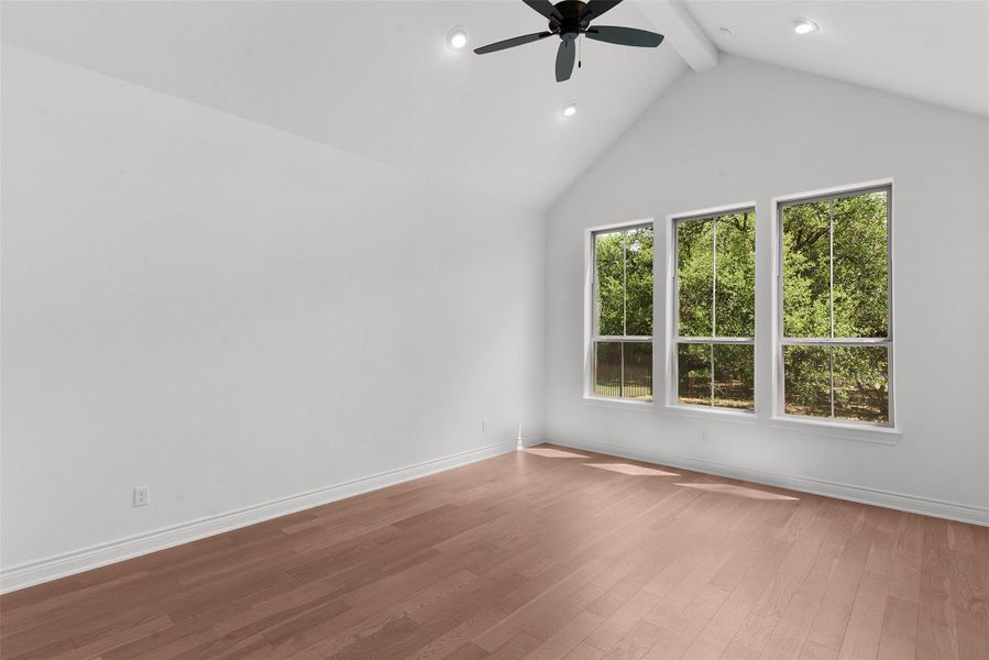 Hardwood floors and a vaulted ceiling elevate this sun-drenched space, perfect for quiet relaxation.