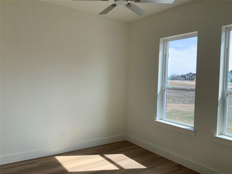 Unfurnished room featuring dark wood finished floors and ceiling fan Unfurnished room featuring dark wood finished floors and ceiling fan