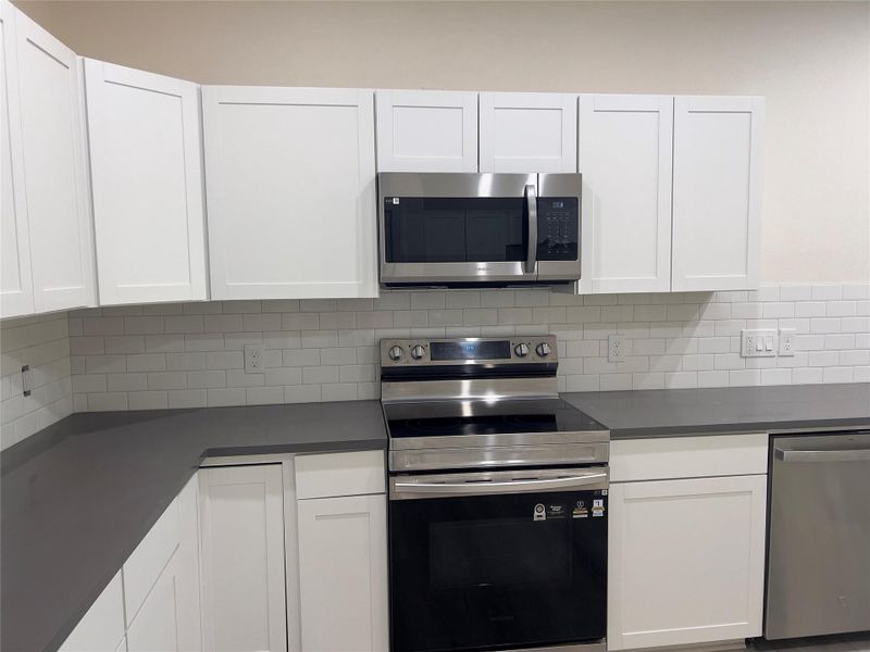 Modern kitchen with sleek cabinetry and essential appliances.