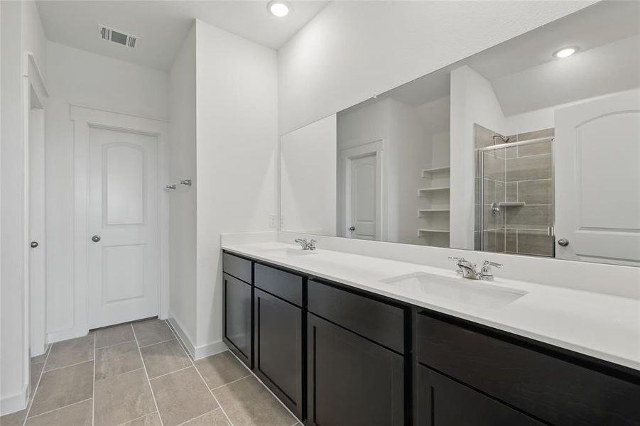 Full bathroom with visible vents, a sink, a shower stall, double vanity, and tile patterned flooring Full bathroom with visible vents, a sink, a shower stall, double vanity, and tile patterned flooring