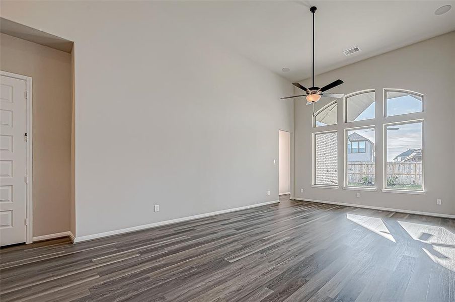 Spacious family room featuring a wall of windows that offers stunning views of the backyard patio.